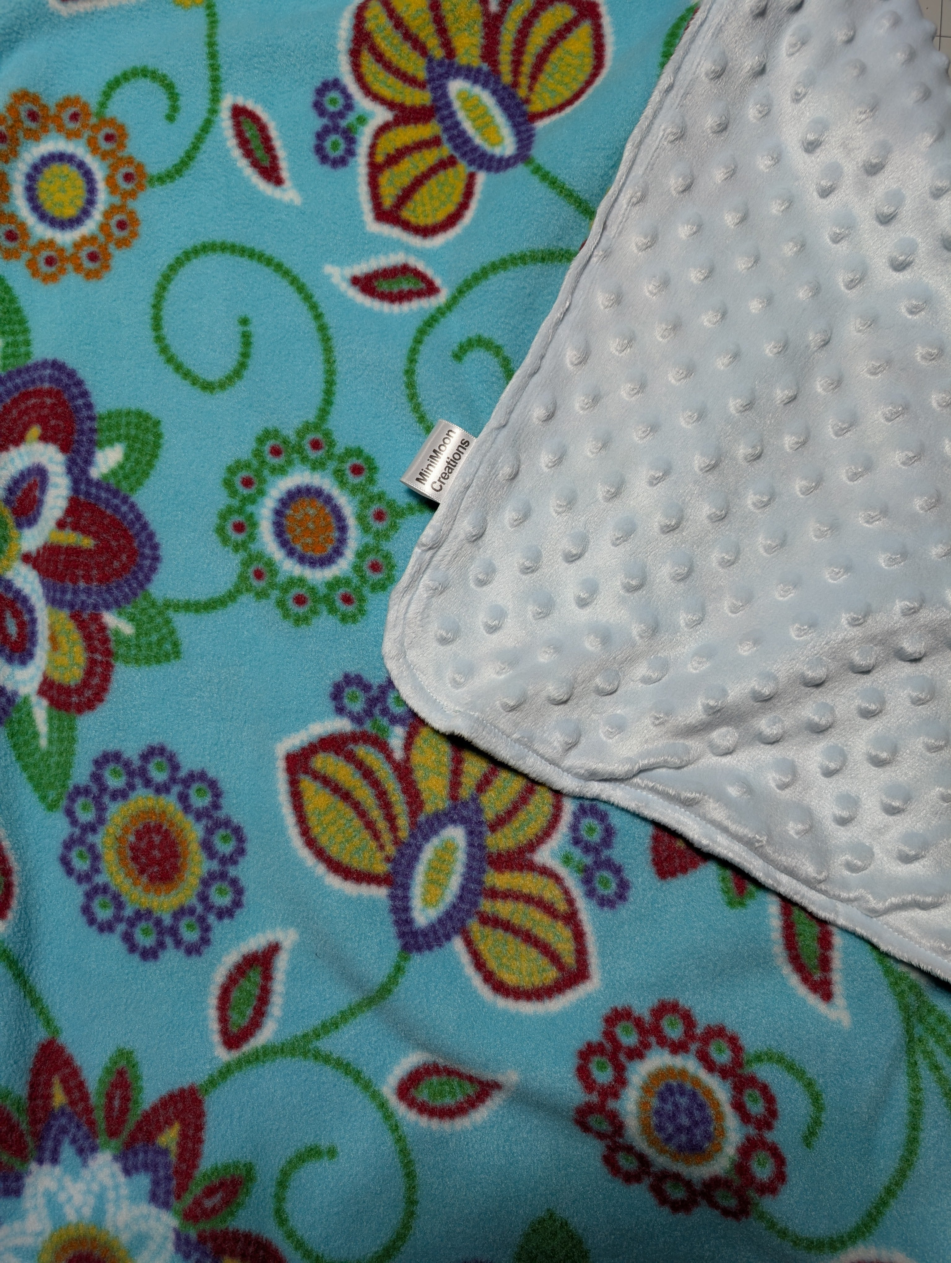 Doudou pour enfant fleuri turquoise